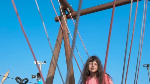 Happy Girl Swinging on Playground Set, Daytime