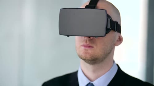 Man Wearing VR Headset Gesturing in Office