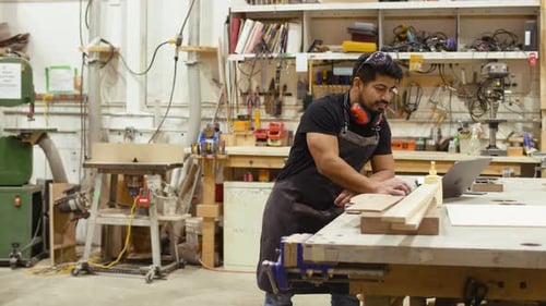 Carpenter Planning at Workbench in Workshop