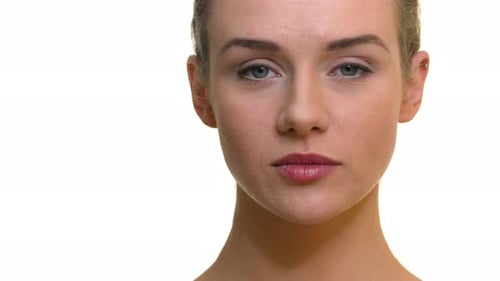 A close-up of a woman's face with a neutral expression