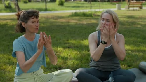 Qi Gong Trainer Explaining Arm Movements to Seniors after Practice in Park