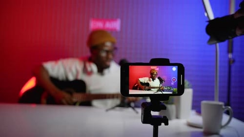 Man Playing Guitar Recording Video at Home