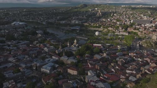Aerial top down shot of Tbilisi Cityscape with Kura River in Georgia during dusk