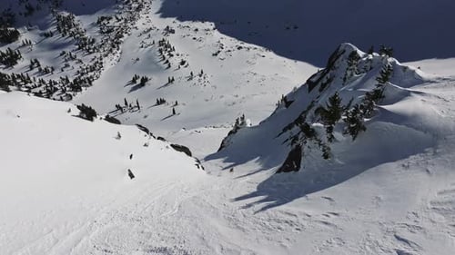 Skier Descending Snowy Mountain Slope