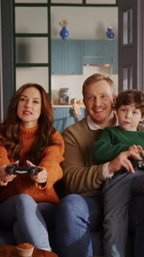 Joyful Family Plays Video Games Together on Couch