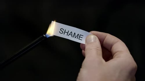 Burning Away Shame - Hand Setting Fire to Paper note Marked “SHAME”, Powerful Release of Criticism,