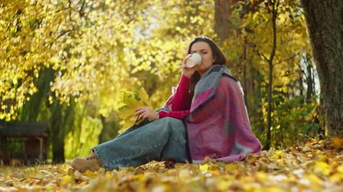 Romantic Caucasian Woman Drinking Tea in Autumn Park