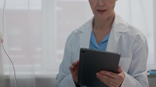 Doctor Using Tablet Beside Patient in Hospital Room