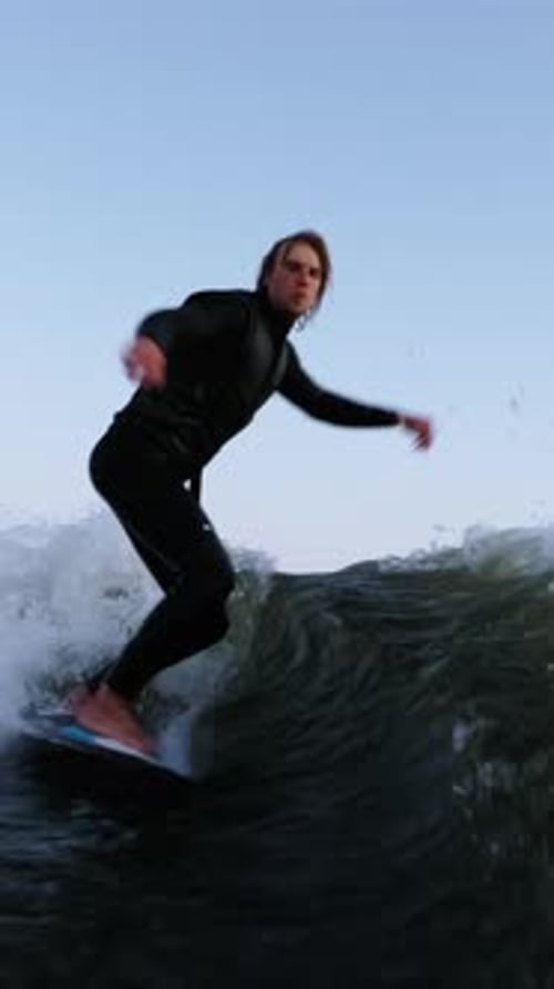 A Thrilling Surfing Session Capturing the Dynamic Movement and Skill of a Surfer Riding the Waves