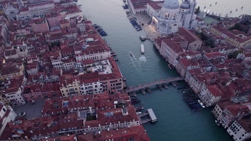 Aerial view of church, canal, boats, and sunrise, Italy.