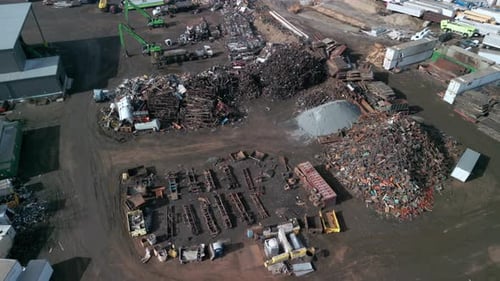 Weite Luftaufnahme über dem Lader, der Metallschrott schnappt und lädt