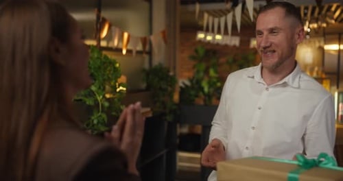 Man Receiving Birthday Gift at Workplace from Woman