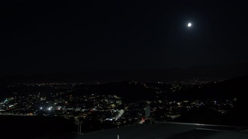 Moon over the illuminated cityscape of Wellington at nighttime in New Zealand