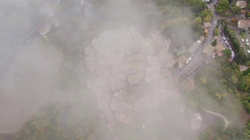 Aerial view of medieval village with Roman church in autumn clouds, Italy.