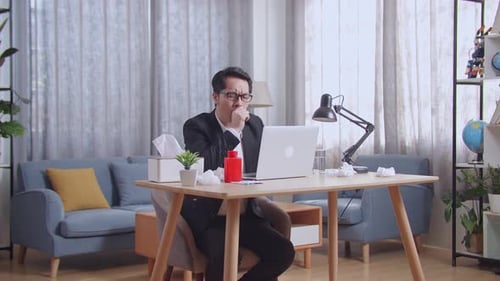 Sick Adult Working at Home With Laptop