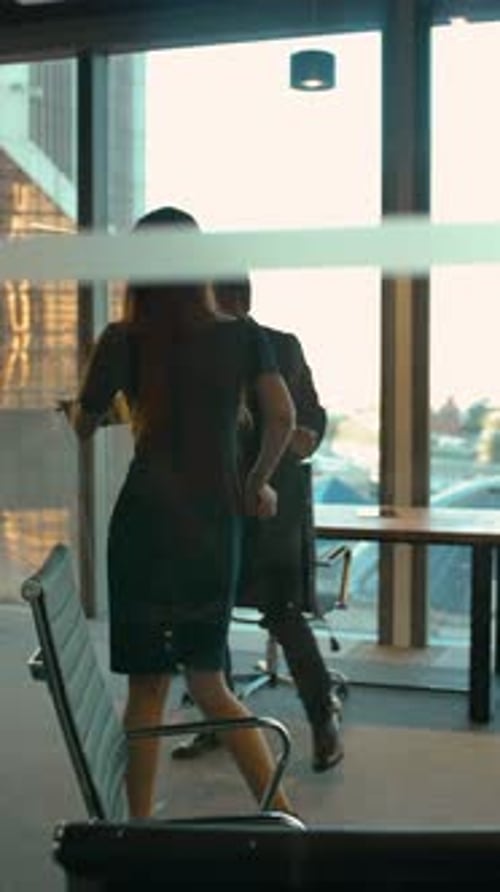 Vertical of Handsome Man and Sexy Woman in Business Office Dancing After Winning