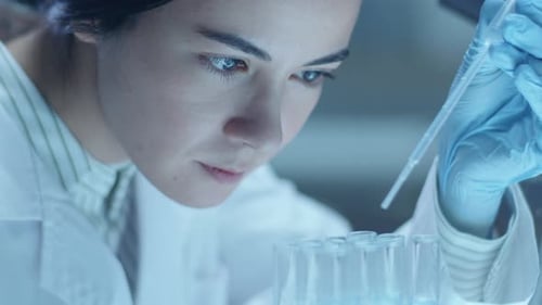 Female Scientist Working with Pipette in Laboratory