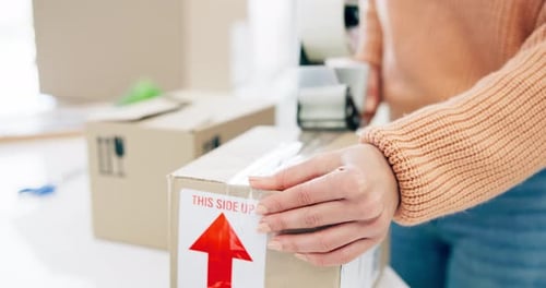 Woman Seals Box With Tape Gun
