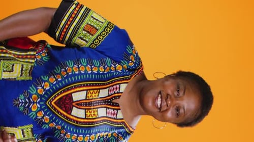 Smiling Woman Giving Thumbs Up on Orange Background