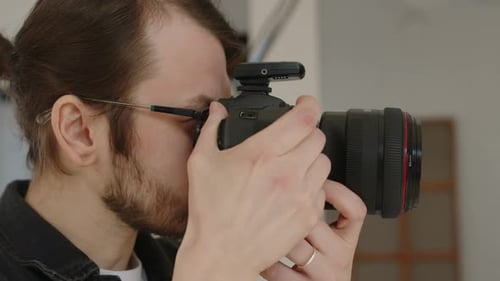 Man Takes Photograph with Professional DSLR Camera
