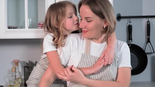 Happy Child Hugs Mother in Sunny Kitchen