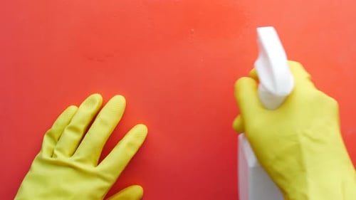 Hands Spraying Cleaning Solution Wearing Yellow Gloves