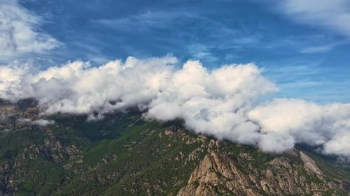Clouds rolling over mountain peaks in a breathtaking landscape