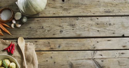 Overhead view of cooked potatoes and multiple food ingredients on wooden surface