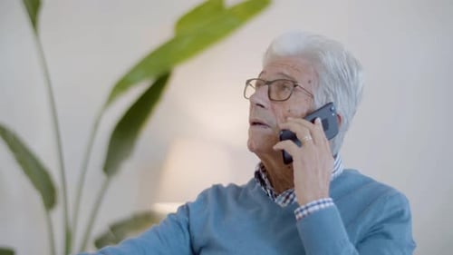 Elderly Man Chatting on Smart Phone Indoors