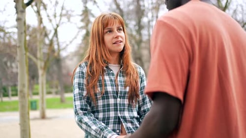 Young Couple Holding Hands in Park Sharing a Tender Moment