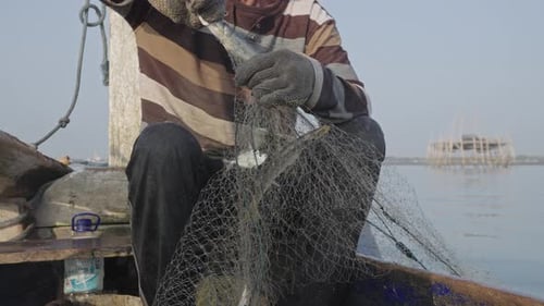 Skilled hand of traditional fishermen in Muncar, a coastal village in East Java, Indonesia. Retrievi