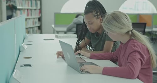 Two Female University Students using Laptop in Library Learning