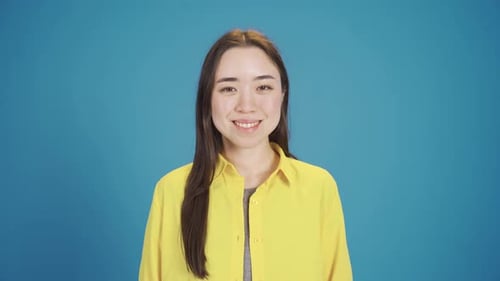 Smiling young Asian woman looking at camera fun and happy.