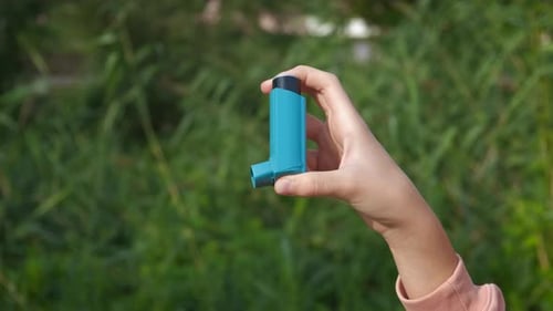 Adolescent with Inhaler in Nature