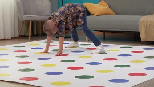 Close Up Shot of Room Twister Game on the Floor Boy Playing Alone Stepping on Colorful Areas with