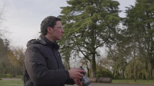 Man photographing outdoors in park with camera