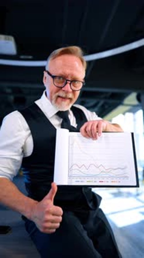 Enthusiastic Caucasian businessman displaying charts.