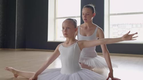 Ballet Teacher Helping Girl to Pull Her Body to Legs at Training