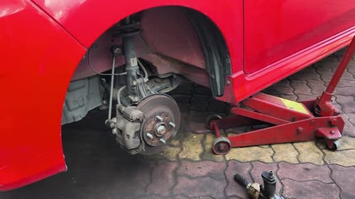 Red Car Tire Change Using Red Jack