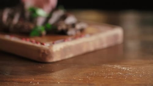 Sliced steak served on wooden cutting board