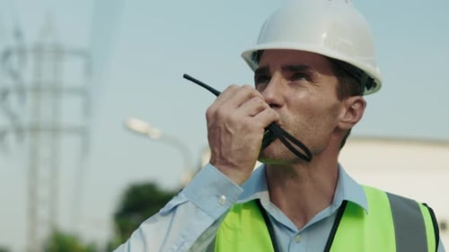 Porträt eines vielbeschäftigten Ingenieurs, der über Walkie Talkie spricht
