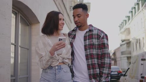 Multiethnic Couple in Love Walks Along the Narrow Streets of a European City The Guy and the Girl