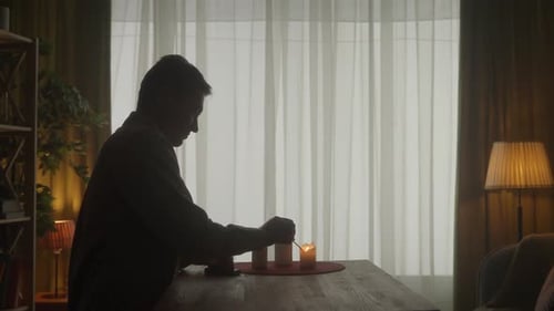 A Man Lights Candles with Matches a Woman Brings Glasses of Wine The Woman Passes One Glass to the