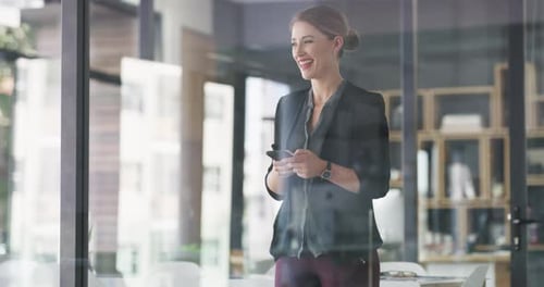 Woman Smiles, Talks on Phone in Modern Office