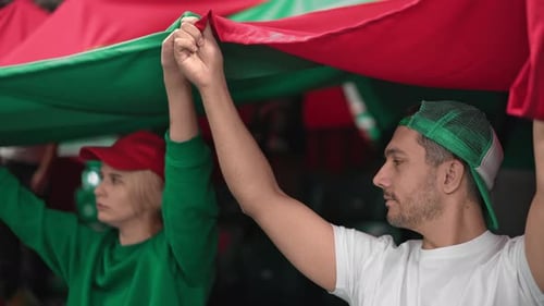 Fans Holding Up Red and Green Flag