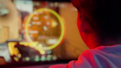 Intense Gamer Playing on Computer at Night