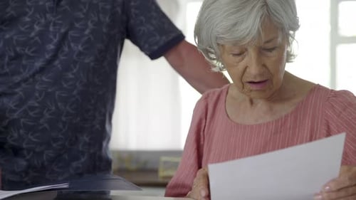 Senior Couple Meeting with Financial Advisor Reviewing Paperwork 5054 Years