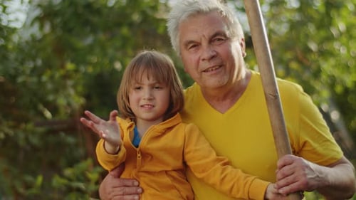 Loving Grandfather With Child Waving Outdoors