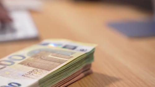 Stack of Euro Banknotes on Desk in Office
