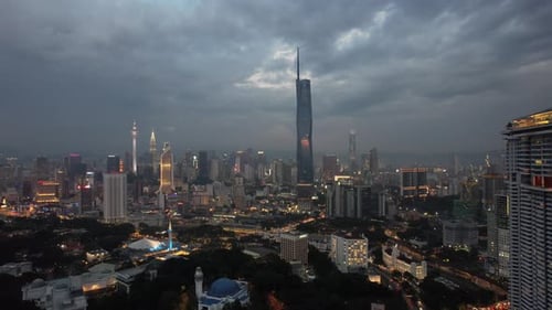 Aerial drone of city skyline in Kuala Lumpur Malaysia during dusk night hour track back shot